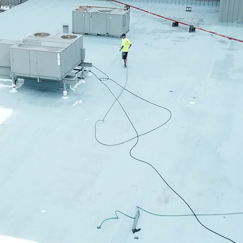 Roofers apply silicone coating.